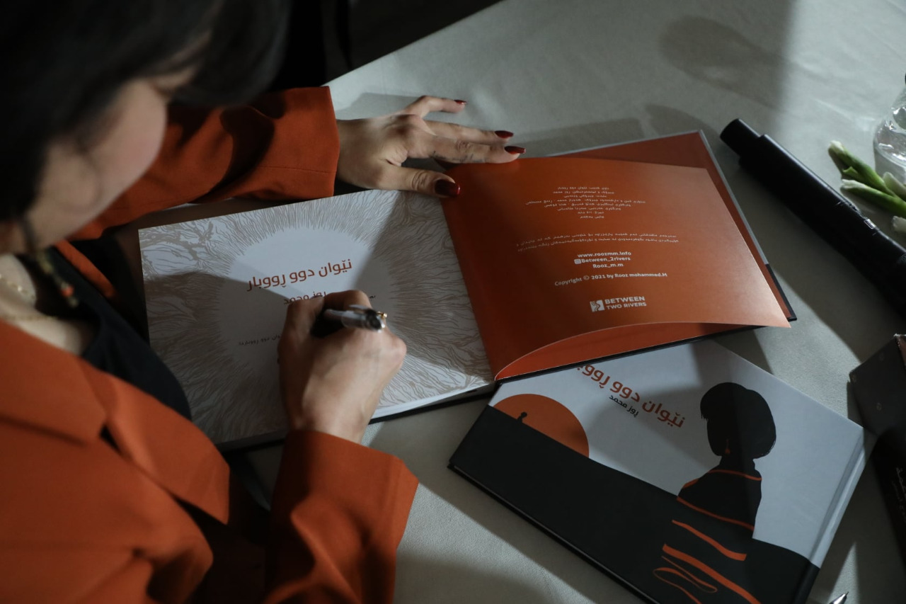 Roos Mohammed signs a copy of her graphic novel Between Two Rivers. (Photo: Luna Darwesh/Facebook).